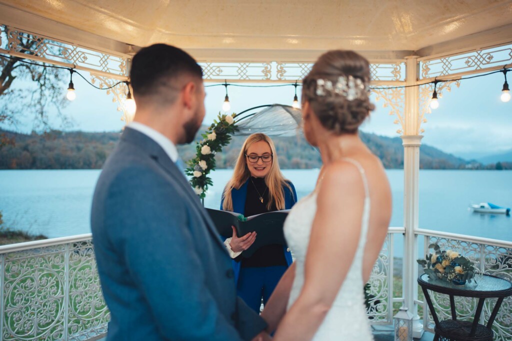 Bride and Groom looking out onto Lake Windermere in front of Celebrant