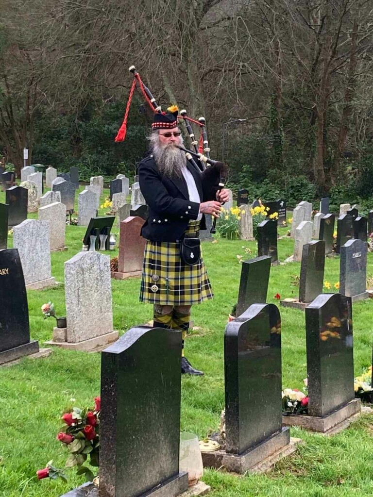 Cornish piper playing by graveside at a funeral