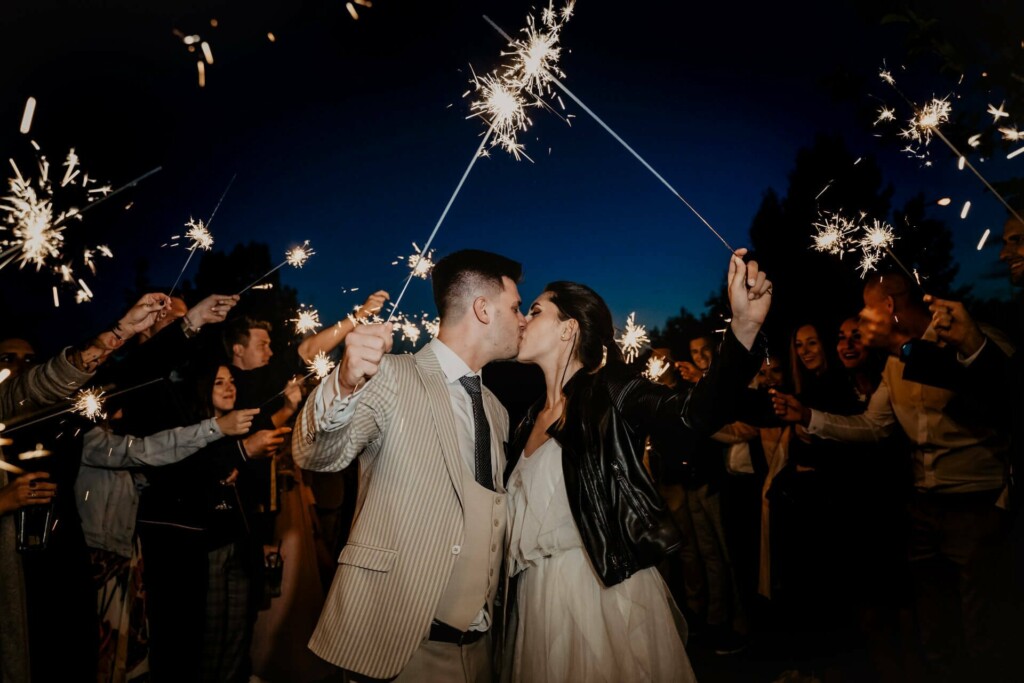 A couple with sparklers at the end of a vow renewal ceremony party