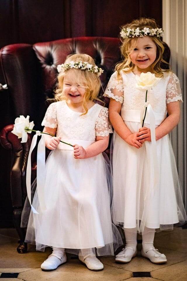 Two smiling flower girls at a wedding