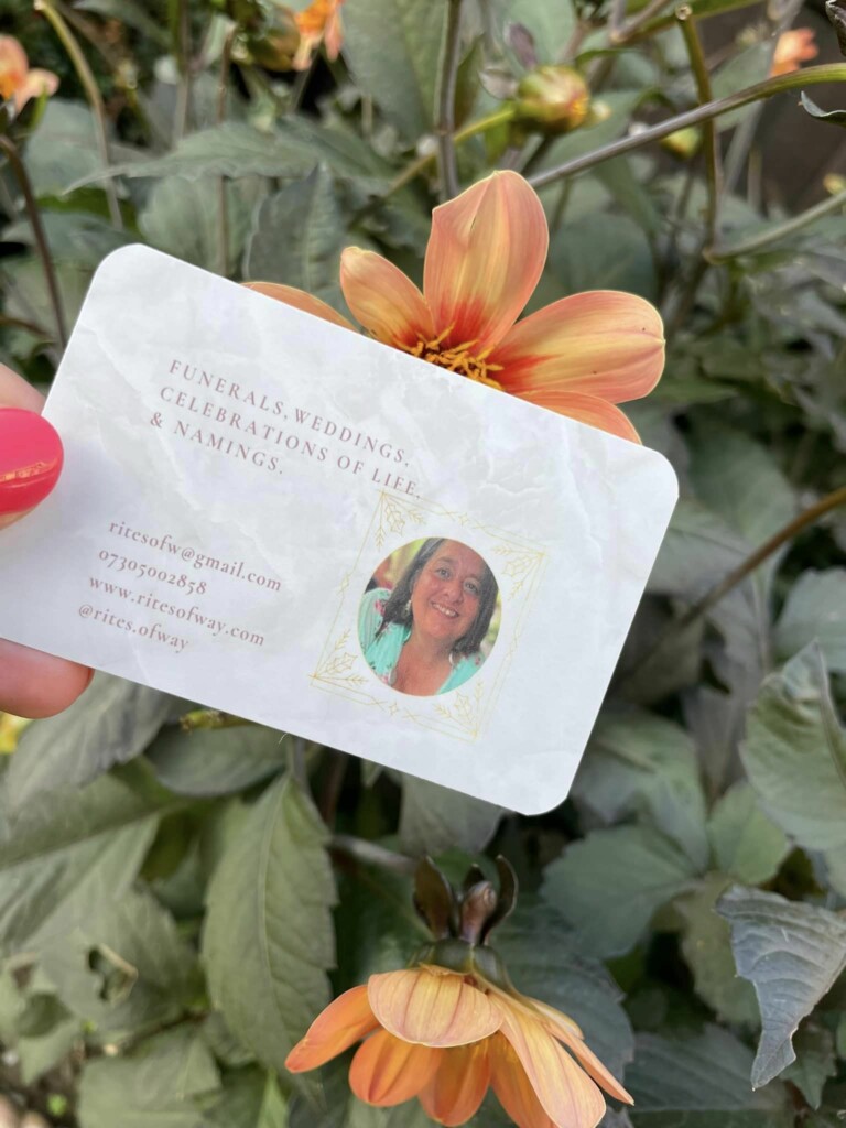 Carolyn, the Celebrant business card next to flowers in her garden