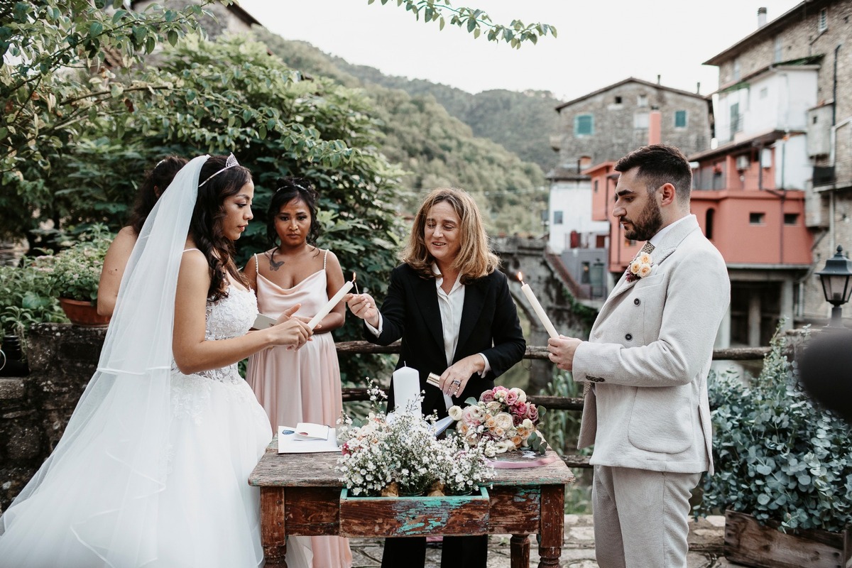 a celebrant leads a couple through a Unity candle ceremony at their wedding