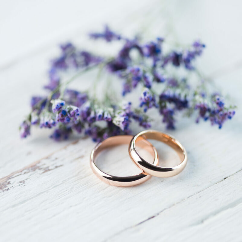 Close-up,View,Of,Golden,Wedding,Rings,And,Beautiful,Small,Blue