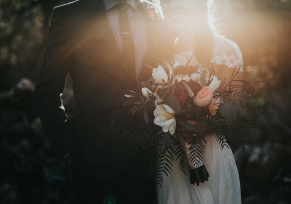 man and woman holding flowers on wedding day.jpg